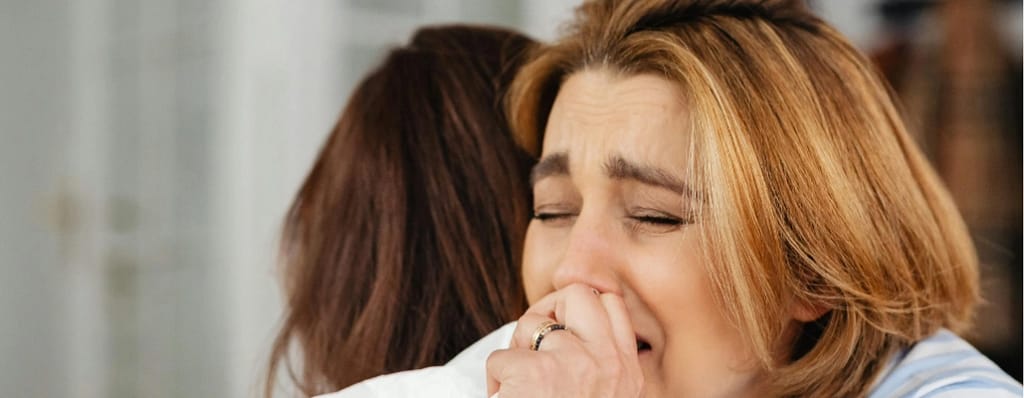 Perdão na bíblia - duas mulheres abraçadas chorando com o coração perdoador uma com a outra.