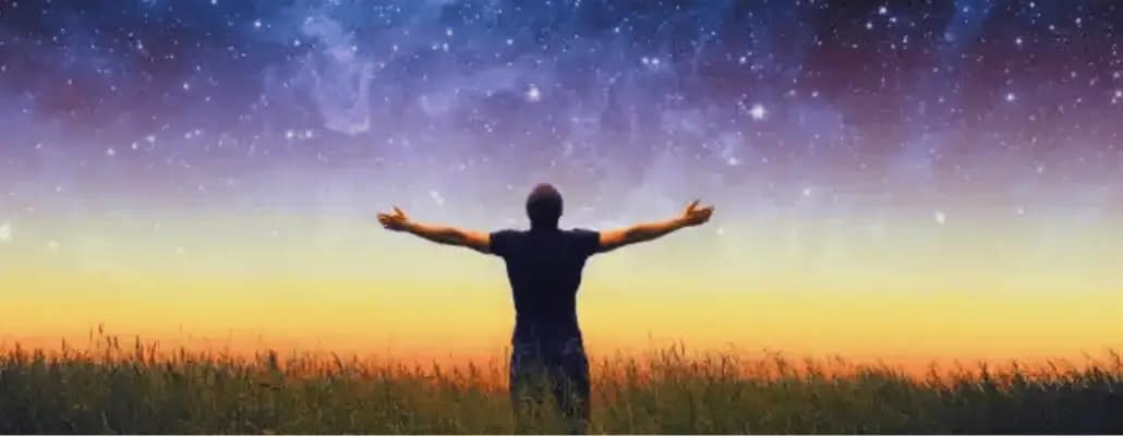 Homem na relva olhando para o céu em agradecimento a Deus