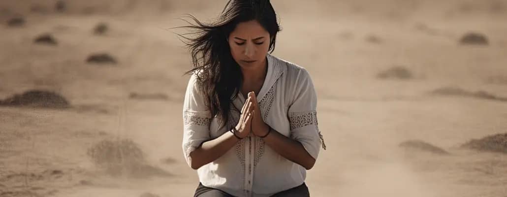 Mulher de joelhos no deserto sendo humilde demonstrando como cuidar da espiritualidade