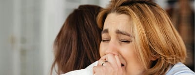 Perdão na bíblia - duas mulheres abraçadas chorando com o coração perdoador uma com a outra.