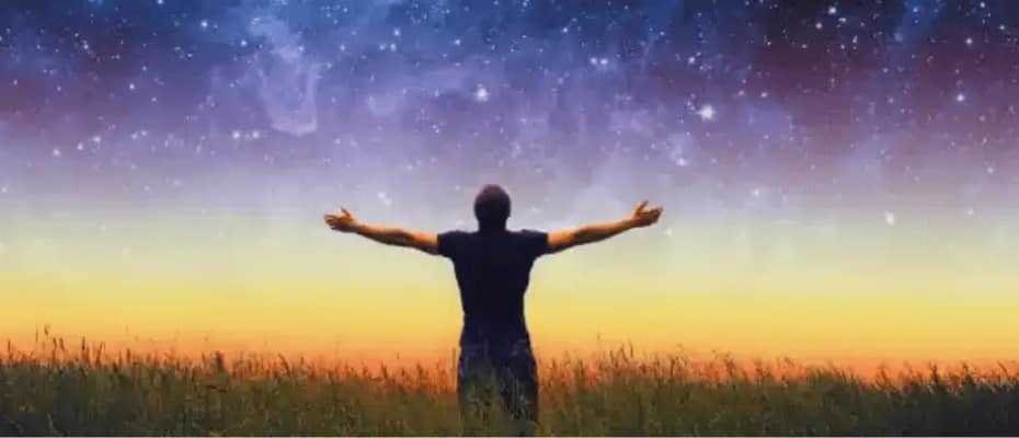 Homem na relva olhando para o céu em agradecimento a Deus